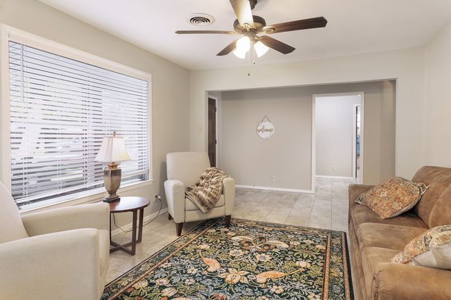 Living room with visible vents, baseboards, and ceiling fan | Image 6