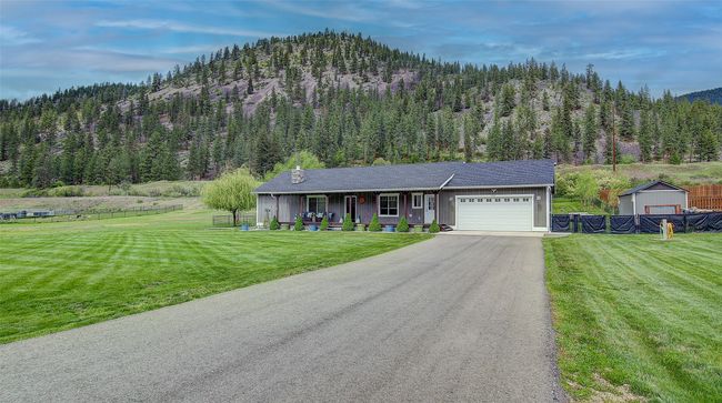 Single story home featuring a garage, a porch, a view of trees, asphalt driveway, and a mountain view | Image 31