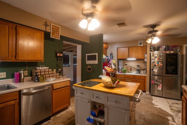 Kitchen featuring appliances with stainless steel finishes, ceiling fan, wooden counters, and brown cabinetry | Image 11