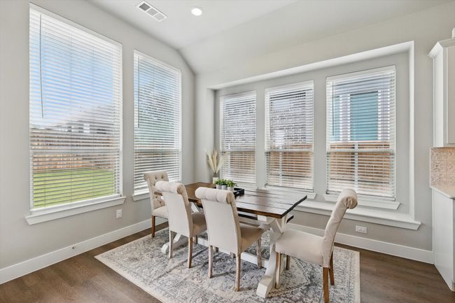 Dining space with plenty of natural light, lofted ceiling, and dark wood-style floors | Image 10