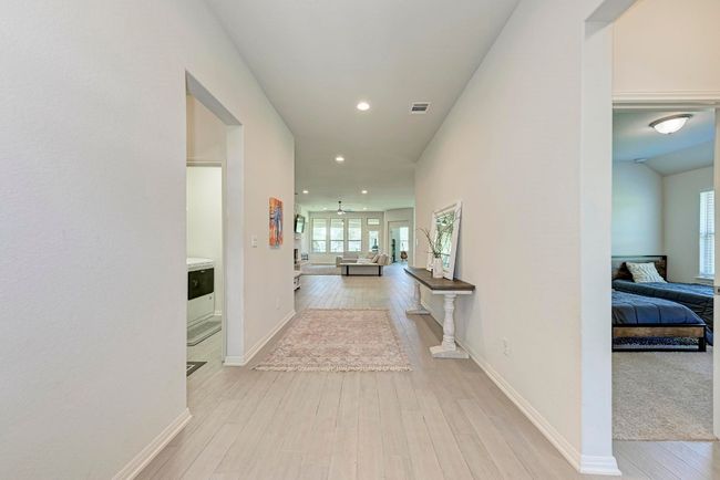 The floyer flows into the hallway and reveals secondary bedrooms. To the Right are two secondary bedrooms and Hollywood-style bath; to the Left another secondary bedroom, indoor utility room and access to the garage. | Image 29