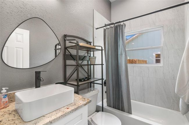 Modern full bath with stylish fixtures and ample natural light. | Image 7