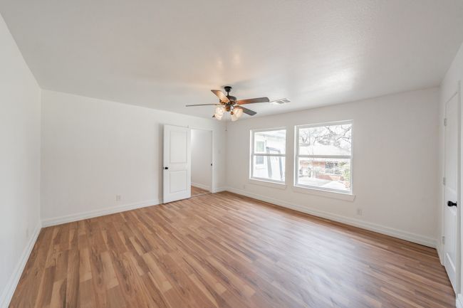 Empty room featuring light wood-type flooring, baseboards, and a ceiling fan | Image 14