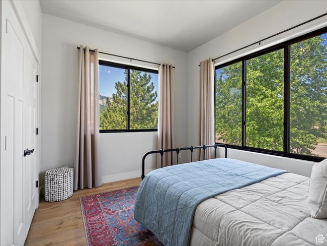 Bedroom with multiple windows, wood finished floors, and baseboards | Image 32