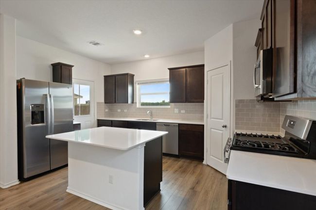 Kitchen with visible vents, a sink, dark brown cabinetry, light wood-style floors, and appliances with stainless steel finishes | Image 6
