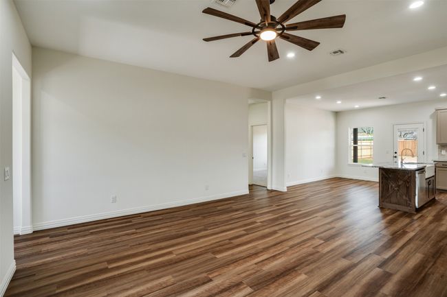 Unfurnished living room with dark wood-style flooring, baseboards, visible vents, recessed lighting, and ceiling fan | Image 5