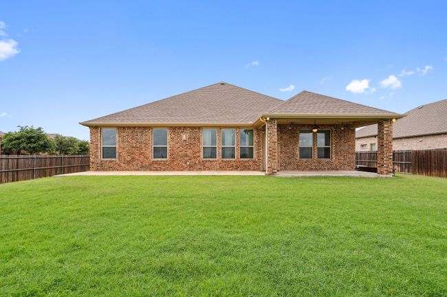 Rear view of house with a patio, a fenced backyard, a shingled roof, and brick siding | Image 4