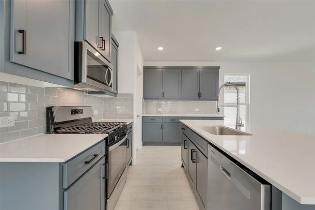 Kitchen with stainless steel appliances, a sink, gray cabinets, tasteful backsplash, and recessed lighting | Image 5