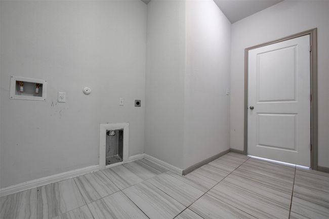 Laundry room with hookup for an electric dryer, washer hookup, gas dryer hookup, light tile patterned flooring, and baseboards | Image 8