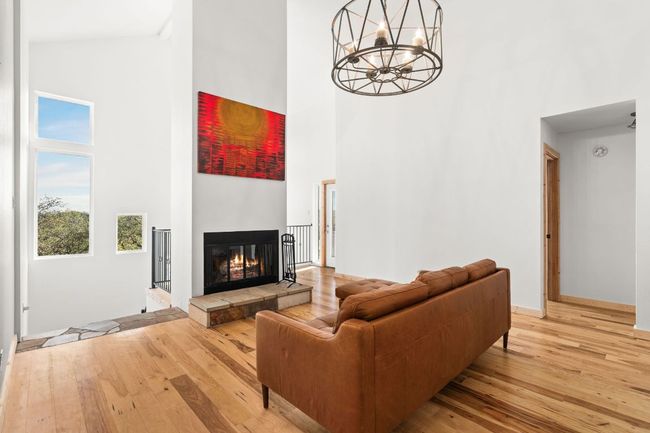 Living area with a towering fireplace, vaulted ceilings and views | Image 11