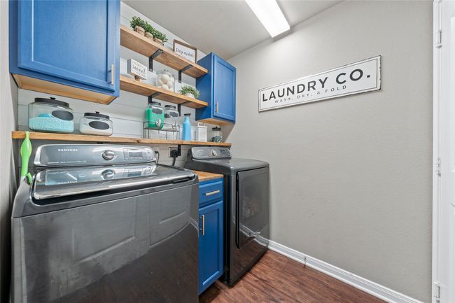 Washroom with washing machine and dryer, dark wood-style floors, baseboards, and cabinet space | Image 6