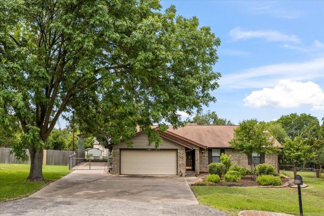 View of front of house featuring driveway, an attached garage, brick siding, and a gate | Image 34