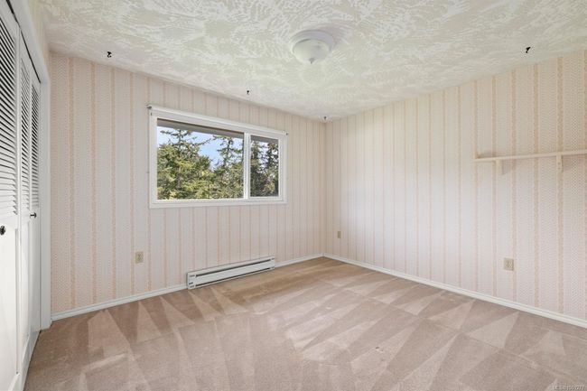 Unfurnished bedroom with a baseboard radiator, a closet, a textured ceiling, and carpet flooring | Image 28