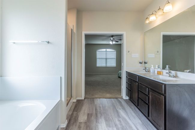 Ensuite bathroom with wood finished floors, a sink, a ceiling fan, and a bath | Image 17