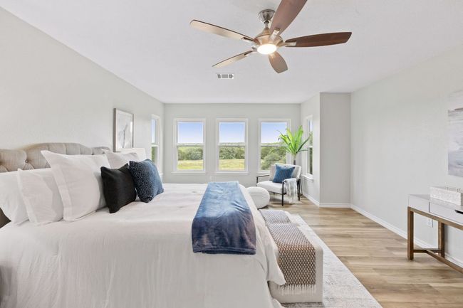 Bedroom with light wood-type flooring, baseboards, and a ceiling fan | Image 29