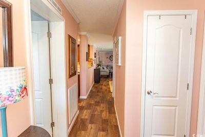 Hallway featuring ornamental molding, dark wood-type flooring, and a textured ceiling | Image 2