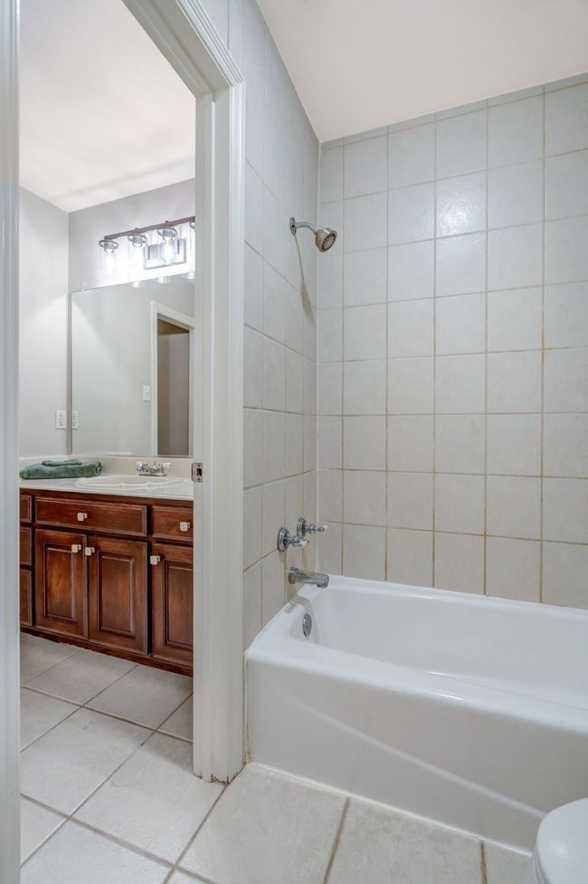 Tiled floors and tubs with updated light fixtures in both secondary bathrooms and plenty of storage space. | Image 35