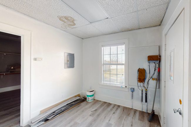 Empty room featuring light hardwood / wood-style floors, electric panel, and a paneled ceiling | Image 27