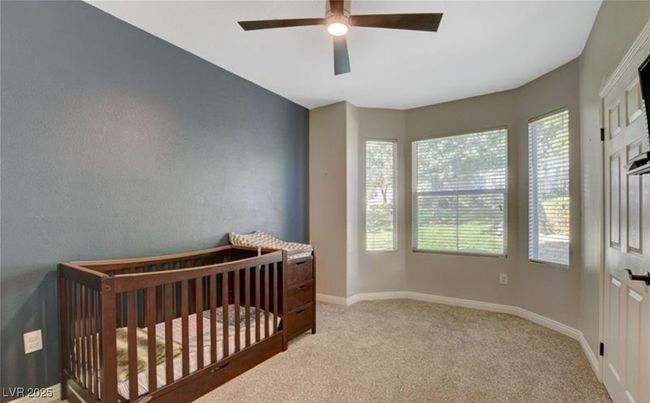 Bedroom with baseboards, a crib, ceiling fan, and carpet flooring | Image 18