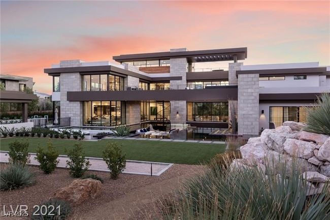 Rear view of house with a yard, a balcony, a patio, and stone siding | Image 47