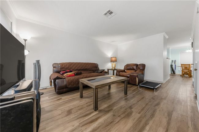 Living room with light wood-style floors and ornamental molding | Image 4