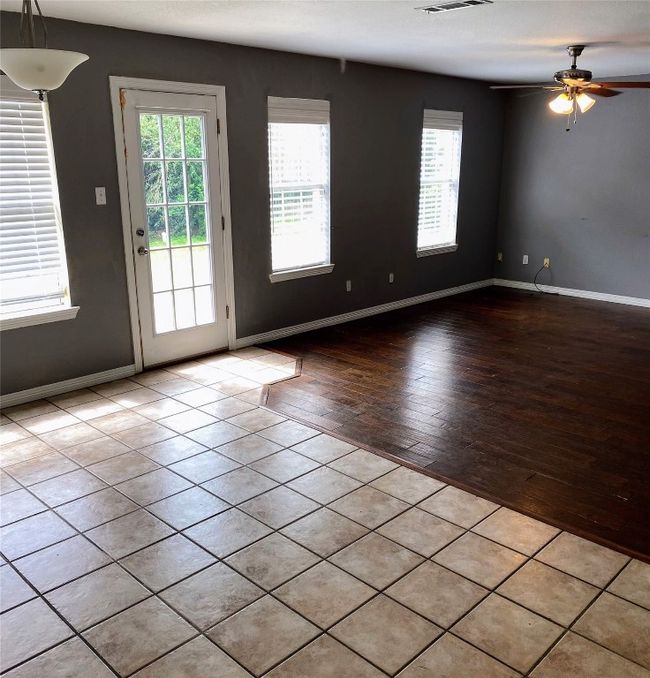 Doorway featuring ceiling fan, visible vents, baseboards, and hardwood / wood-style flooring | Image 10