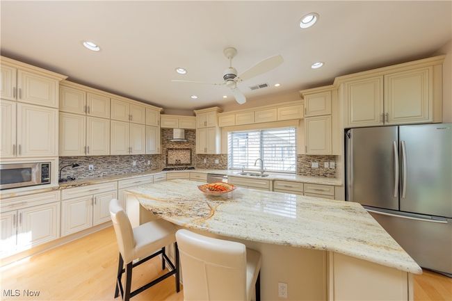 Kitchen featuring granite countertops, large center islan, stainless steel appliances, ceiling Kitchen with skylight, features granite countertops, large center island, plentiful cabinet space, pantry, stainless steel appliances, high ceilings and private catering entrance. | Image 12