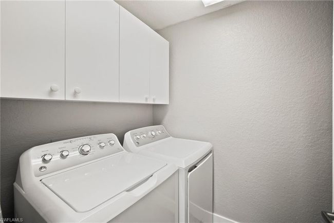 Laundry room with washer and dryer, cabinet space, and a textured wall | Image 32