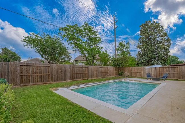 The backyard is low-maintenance with minimal landscaping, offering a clean and open feel. It features a dedicated vegetable garden for homegrown produce and a refreshing pool, creating a perfect balance of relaxation and functionality. | Image 21