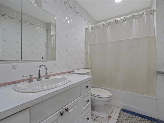 Bathroom with shower / bath combo, toilet, vanity, and tile patterned floors | Image 21