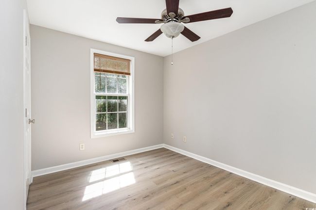 Spare room featuring visible vents, light wood-style floors, a ceiling fan, and baseboards | Image 15