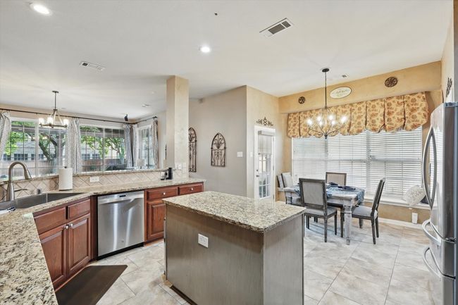 Kitchen with stainless steel appliances, a sink, a center island, and recessed lighting | Image 9