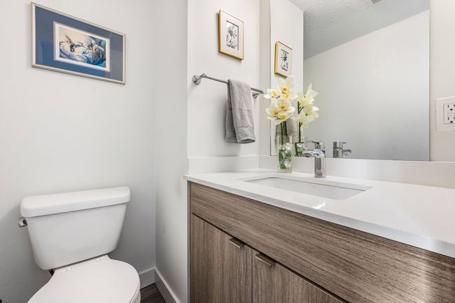 Half bathroom featuring baseboards, toilet, vanity, and a textured ceiling | Image 14