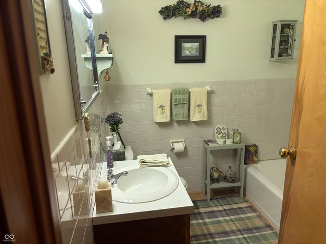 bathroom with vanity, and wall tile, with a tub to relax in | Image 9