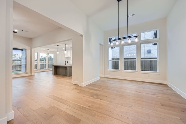 Unfurnished dining area featuring a sink, visible vents, light wood-style floors, and a notable chandelier | Image 7
