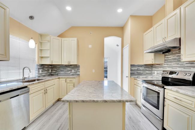 Kitchen featuring a center island, tasteful backsplash, appliances with stainless steel finishes, and plenty of natural light | Image 9
