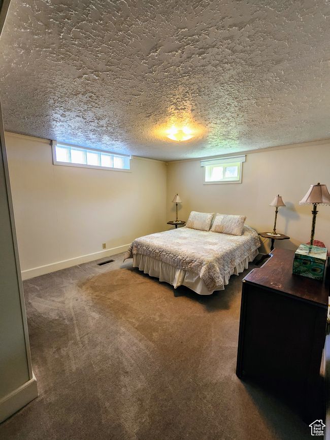 Carpeted bedroom with baseboards, a textured ceiling, and visible vents | Image 40