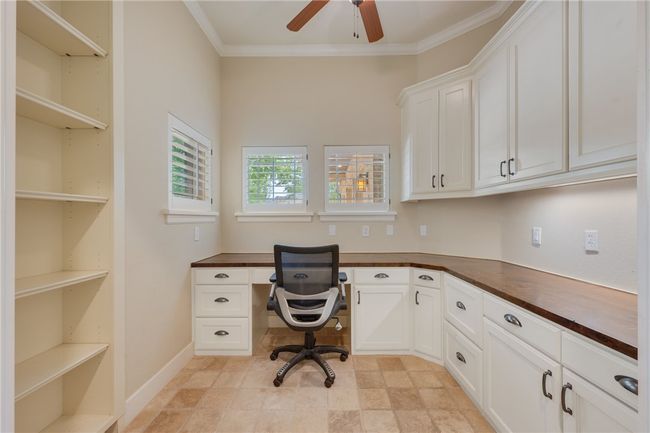 Office area featuring built in study area, a ceiling fan, and crown molding | Image 11