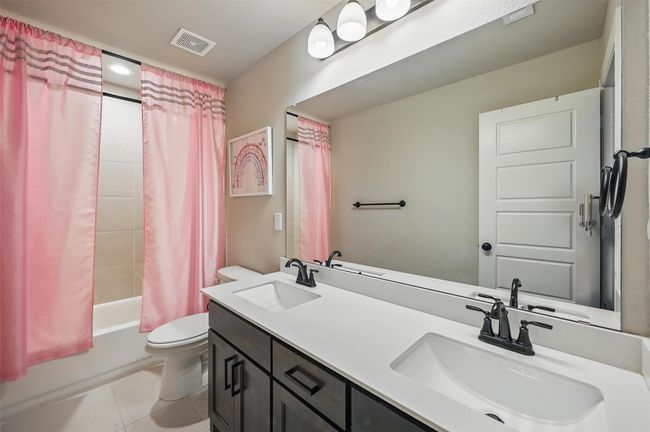 Bathroom featuring tile patterned floors, shower / bath combo, and double vanity | Image 33
