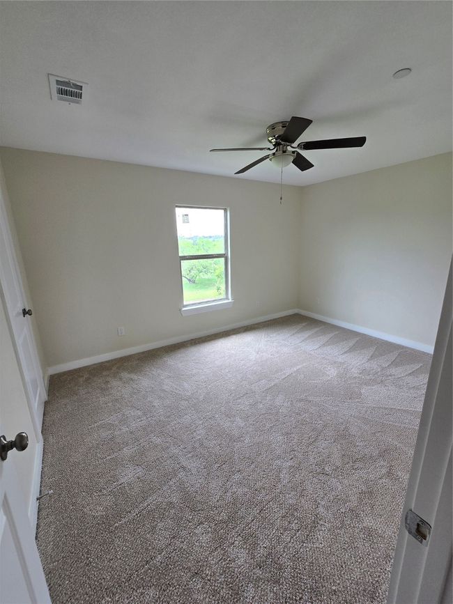 Carpeted empty room with ceiling fan and baseboards | Image 28