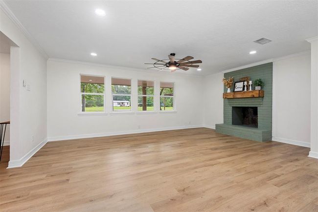 Spacious living room, luxury vinyl plank flooring, recessed lighting, wood burning fireplace and new windows | Image 6