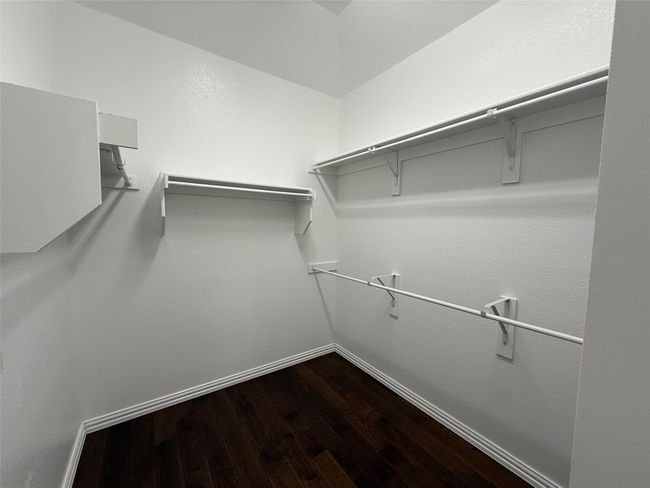 Spacious closet with dark wood-style flooring | Image 11