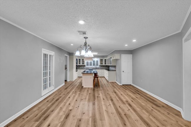 Kitchen featuring a chandelier, a textured ceiling, recessed lighting, tasteful backsplash, and crown molding | Image 10