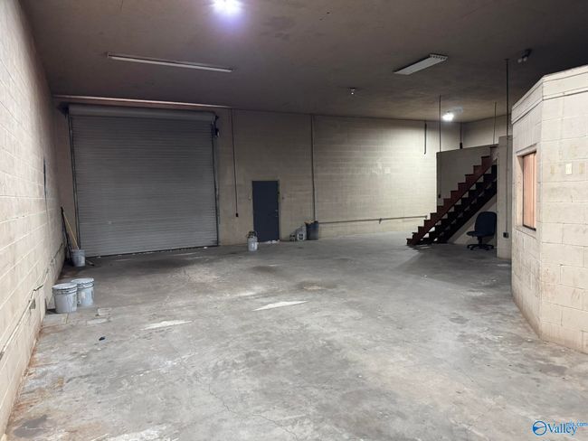 concrete floors, rollup door, walk-in door, steps to storage | Image 6