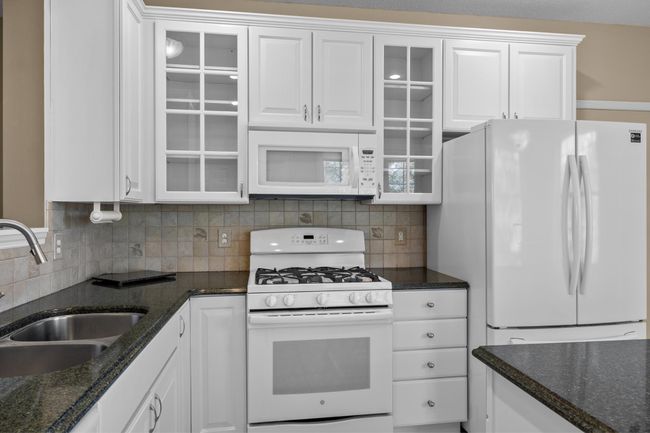 Gas stove, granite countertops, and tile backsplash surround. | Image 18