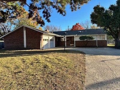 Ranch-style home featuring a garage and a front lawn | Image 1