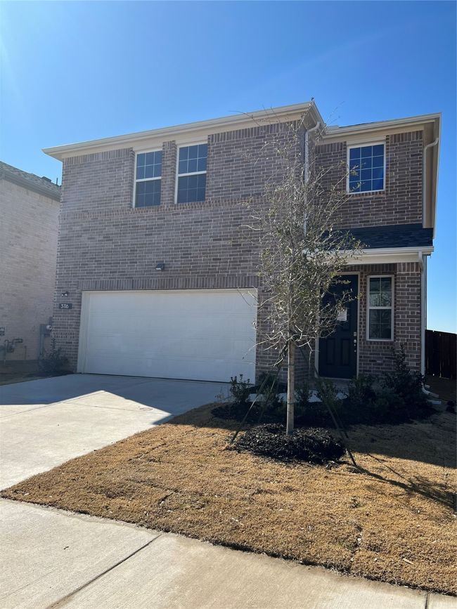 Traditional home featuring concrete driveway, brick siding, and an attached garage | Image 14