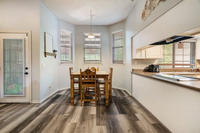Dining area with dark wood-style floors, plenty of natural light, and a textured ceiling | Image 6