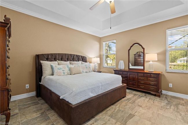 Bedroom featuring a tray ceiling, baseboards, a ceiling fan, and ornamental molding | Image 24