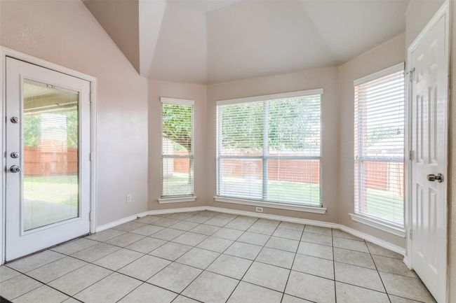 Unfurnished sunroom featuring vaulted ceiling, tile patterned flooring, plenty of natural light, and french doors | Image 12